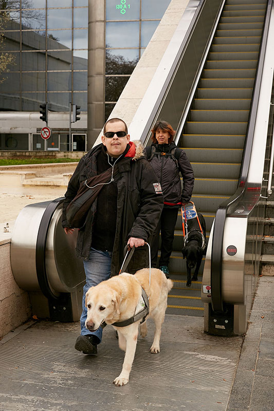 Virgile et Christelle au bas d'un escalator guidés par Dipsy et Jazzy.