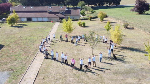 Equipes et bénévoles forment un coeur dans le jardin derrière l'école de Misérieux