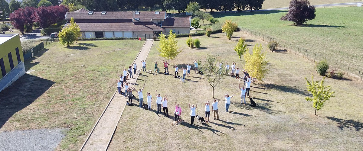 Equipes et bénévoles forment un coeur dans le jardin derrière l'école de Misérieux