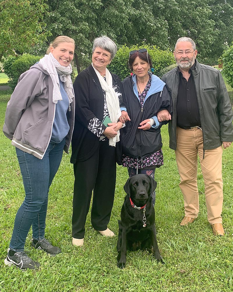 Remise de Tara, dans le parc de l'école. Tara, labrador noir, est assise devant Nadia sa nouvelle maîtresse, entourée de Martine et Christian, famille d'accueil, et Cécile l'éducatrice de Tara.