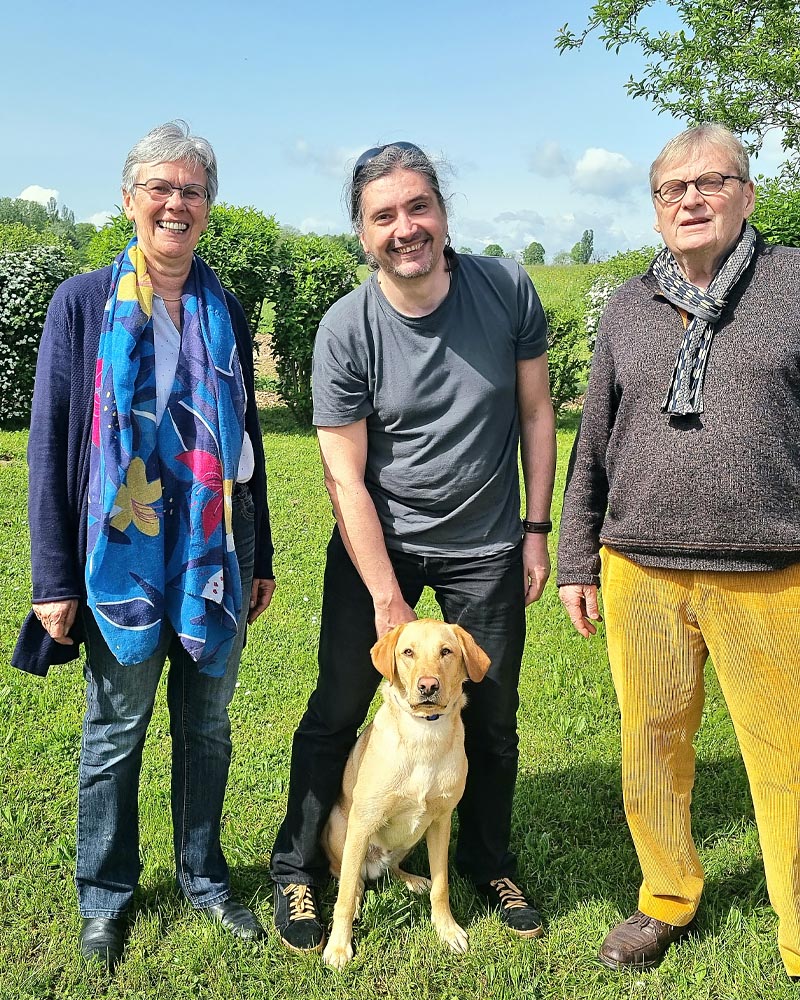 Isabelle et Pascal Bartassot, famille d'accueil de Togo, entourent Christophe Cerri lors de la remise. Togo est assis à ses pieds.