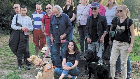 Au parc de la Tête d'Or à Lyon, Hichem Houma, Mario Eljerrat et Régis Ducruix posent, accompagnés de leurs chiens Romie, Ottawa et Népal, entourés d'une dizaine de salariés des laboratoires Boerhinger-Ingelheim.