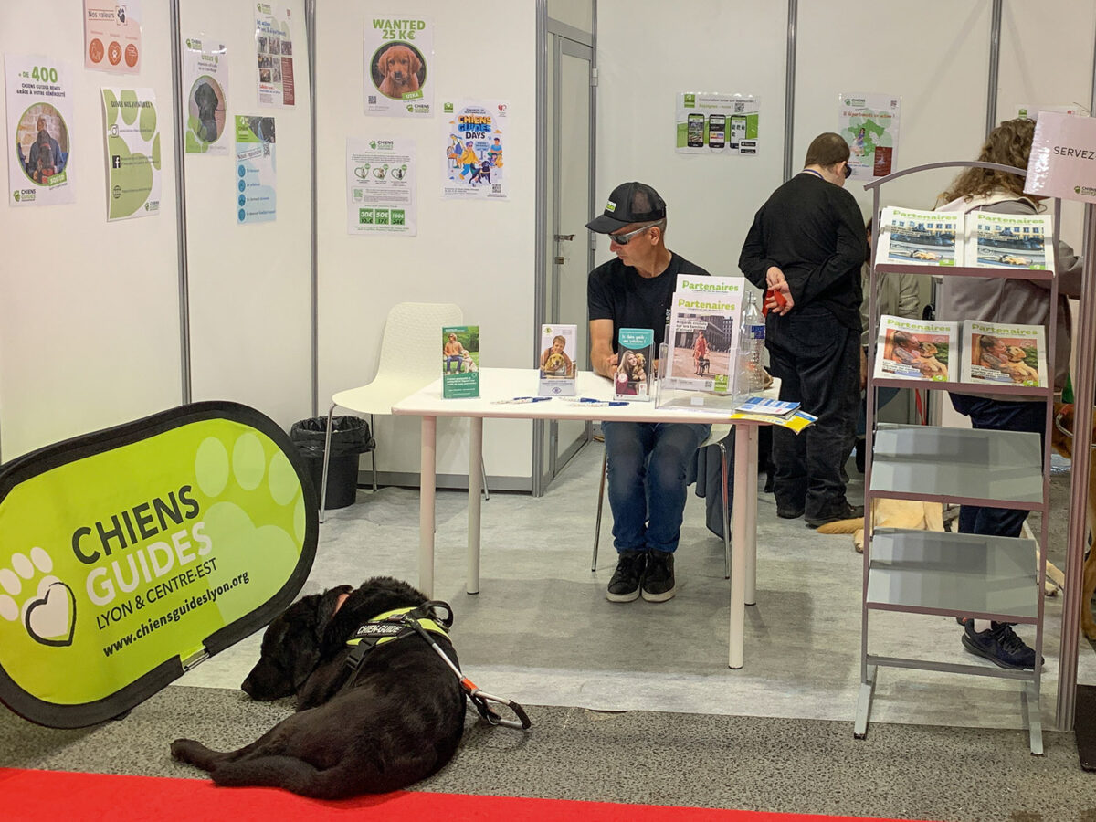 Régis Ducruix et son chien Népal sur le stand de l'association au salon Handica. A l'arrière-plan et de dos, Virgile Jouvenet, également présent sur le stand.