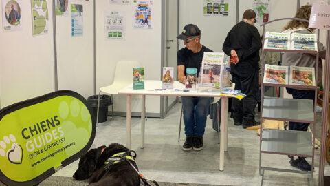 Régis Ducruix et son chien Népal sur le stand de l'association au salon Handica. A l'arrière-plan et de dos, Virgile Jouvenet, également présent sur le stand.