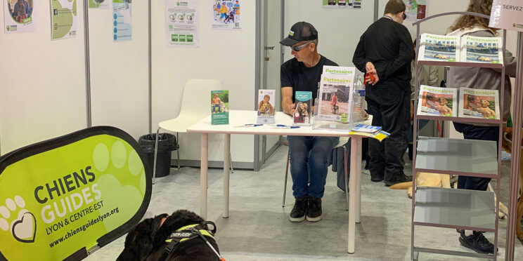 Régis Ducruix et son chien Népal sur le stand de l'association au salon Handica. A l'arrière-plan et de dos, Virgile Jouvenet, également présent sur le stand.