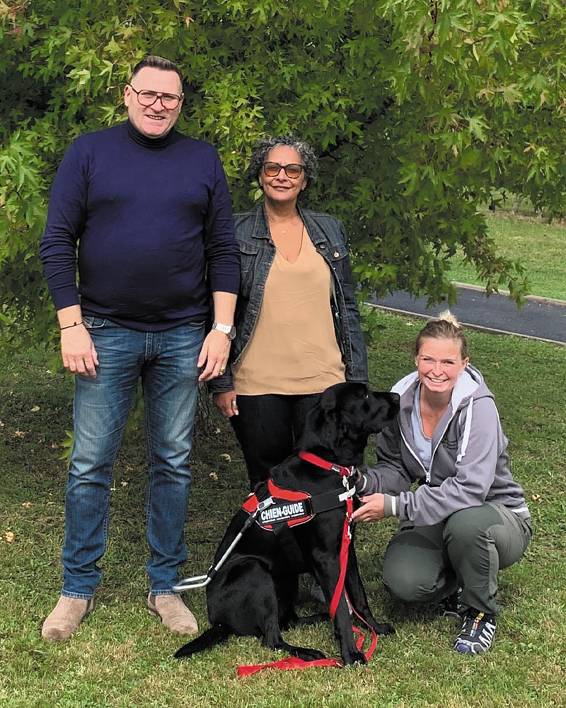 Souad et Taïchi sur fond de verdure dans le parc de l'école, entourés de Laurent, famille d'accueil, et Capucine, éducatrice de Tacos.