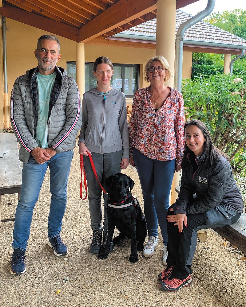 Audrey et Tirex posent lors de la remise, accompagnés d'Adeline l'éducatrice de Tirex, ainsi que de sa famille d'accueil, Franck et son épouse. La photo est prise devant le bâtiment de l'école à Misérieux.