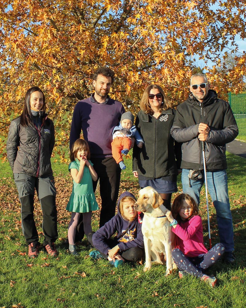 Remise think José-Manuel et Think lors de la remise, entourée d'Estelle (monitrice) et de la famille d'accueil : Charlotte, Grégory et leurs quatre jeunes enfants. Photo prise dans le parc de détente de l'école, devant un arbre flamboyant de ses couleurs d'automne.