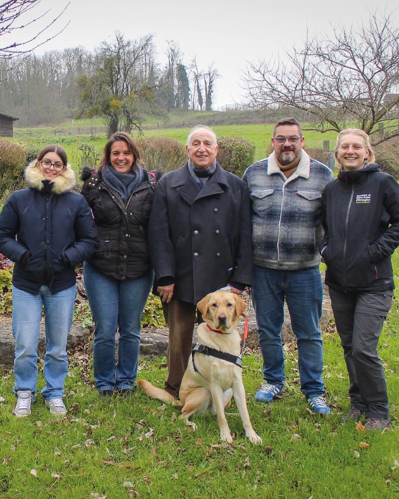Remise twist Jean Fournier et Twist lors de la remise dans le parc de l'école. Ils sont accompagnés d'Eloïse (monitrice) et de la famille Baco. La photo évoque un temps frais, les personnes étant chaudement habillées.