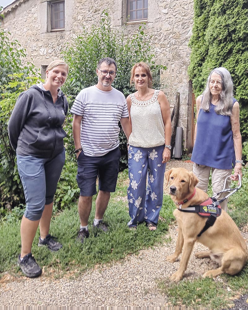 Marie-Claude et Ukatan au jardin, devant une maison en pierre entourée de végétation. A sa droite, Alexandre et Patricia Varet ainsi que Cécile Bailly.