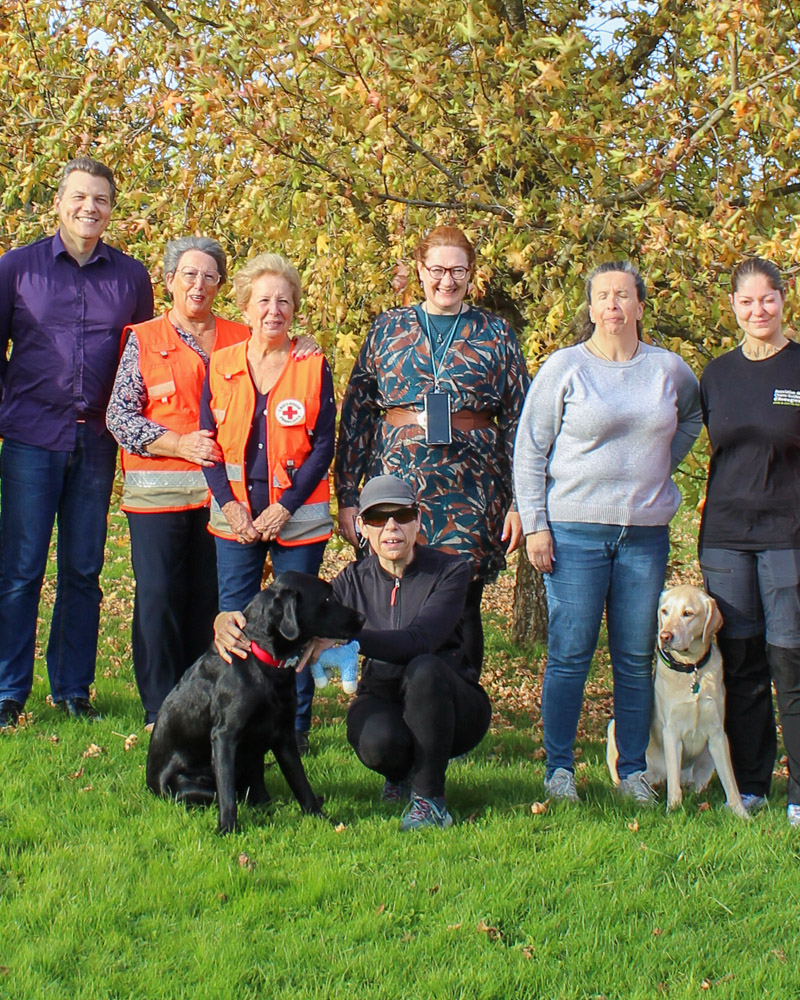 Dans le parc de Misérieux, Isabelle se tient accroupie à côté d'Urius. Elle est entourée par Sandrine et David, ainsi que deux bénévoles de la Croix-Rouge, et son amie Christelle avec Sépia. Adeline est également présente sur l'image.