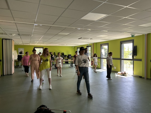 Le groupe composé de voyants et de non-voyants commencent la chorégraphie apprise durant l'atelier en mettant le pied droit en avant.